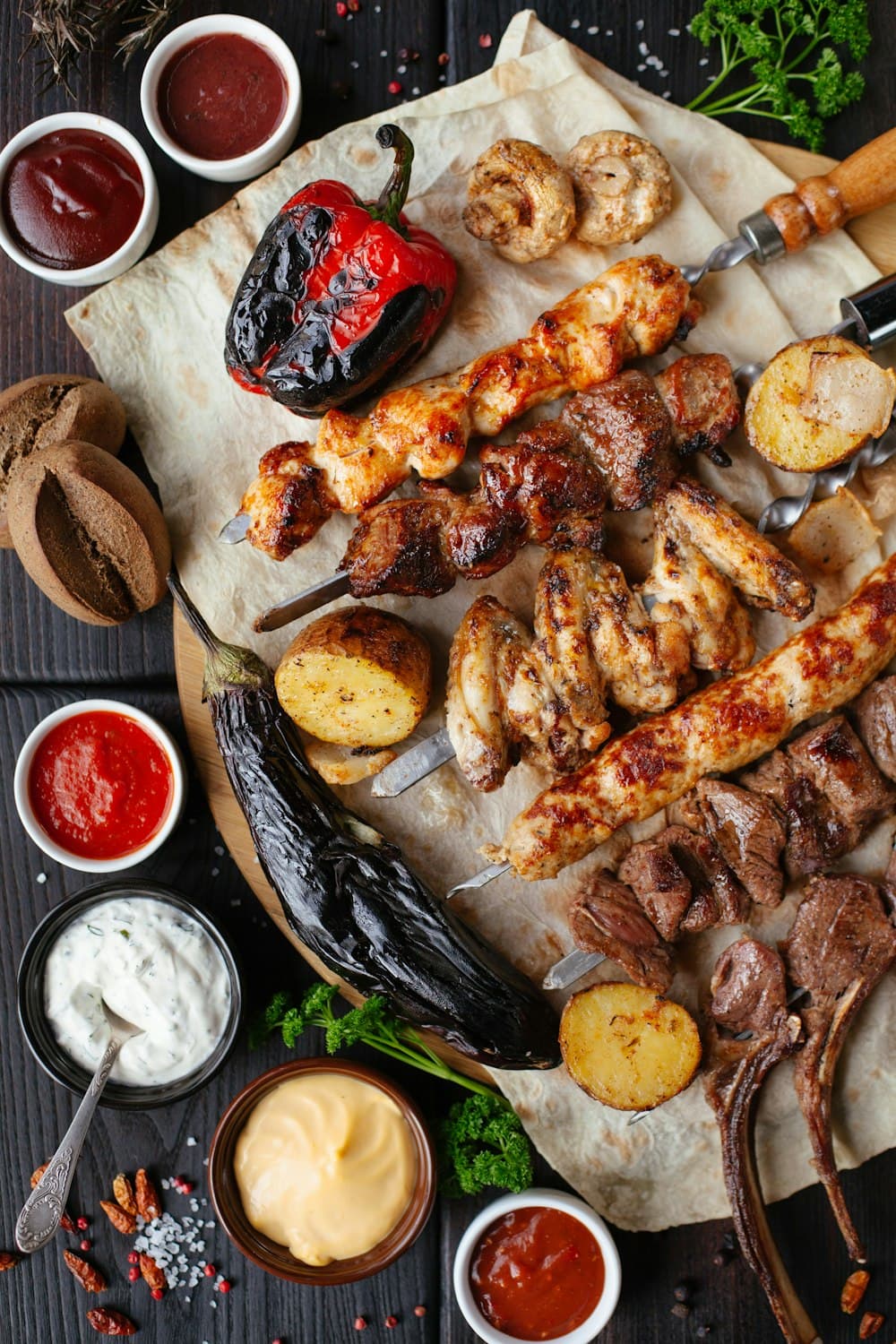 Pitmaster grilling skewers and sweet corn over open hardwood barbecue smoke